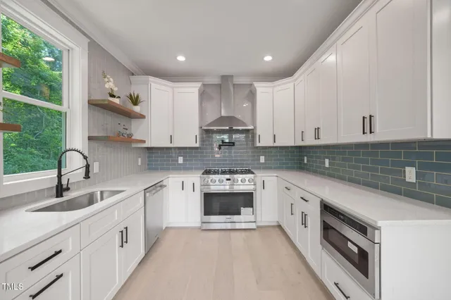 a kitchen with stainless steel appliances granite countertop a sink and cabinets