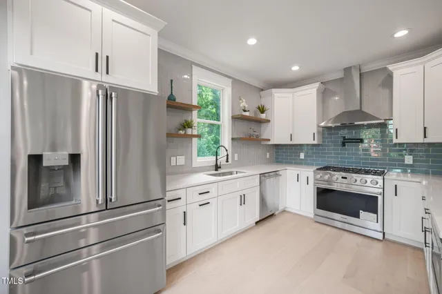 a kitchen with stainless steel appliances granite countertop a refrigerator sink and stove