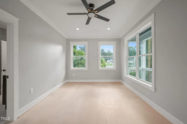 an empty room with windows and ceiling fan