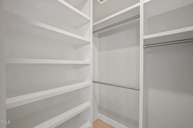 a view of walk in closet with empty racks