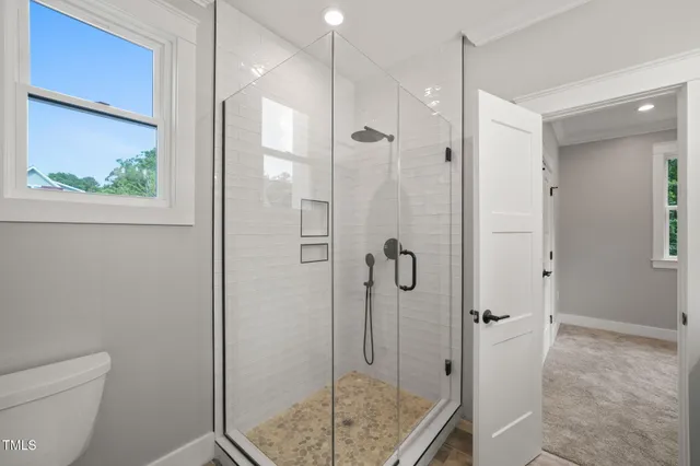 a bathroom with a granite countertop shower a toilet and sink