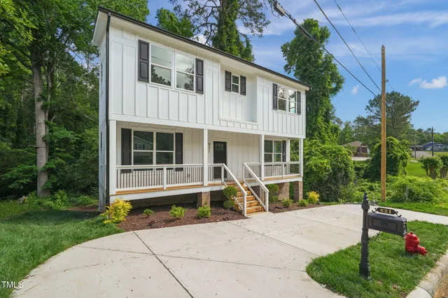 a front view of a house with a yard and potted plants