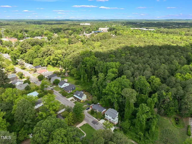 an aerial view of residential house with outdoor space and trees all around