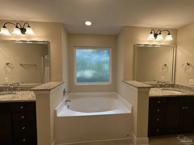 a bathroom with a tub sink and mirror