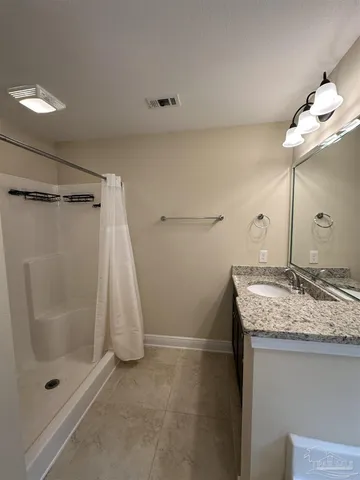 a bathroom with a granite countertop sink a shower and a mirror