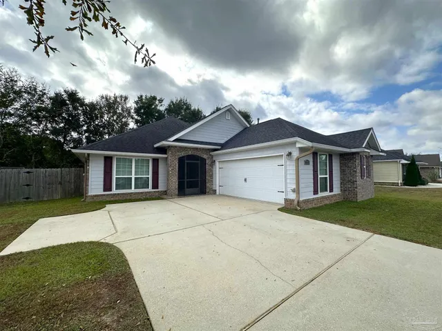 a front view of a house with a garden and yard