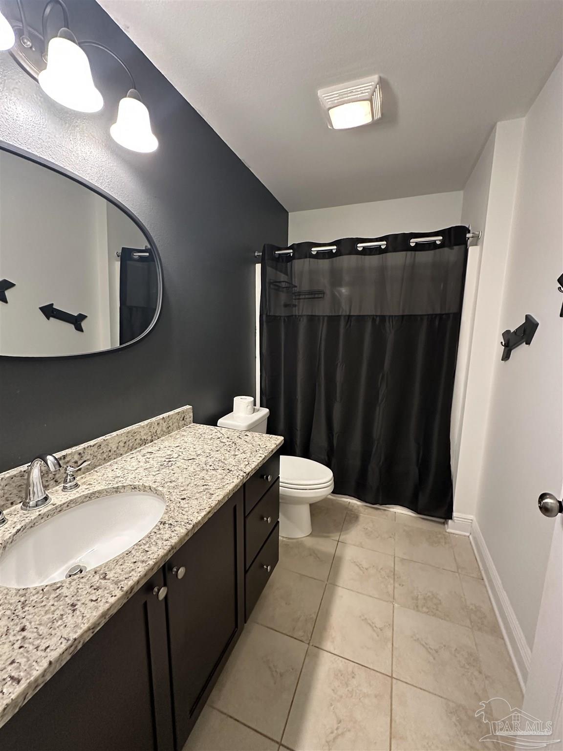 7329 Farmers Road Pensacola, FL 32526 - Photo 21 of 27 a bathroom with a granite countertop sink a toilet a mirror and vanity