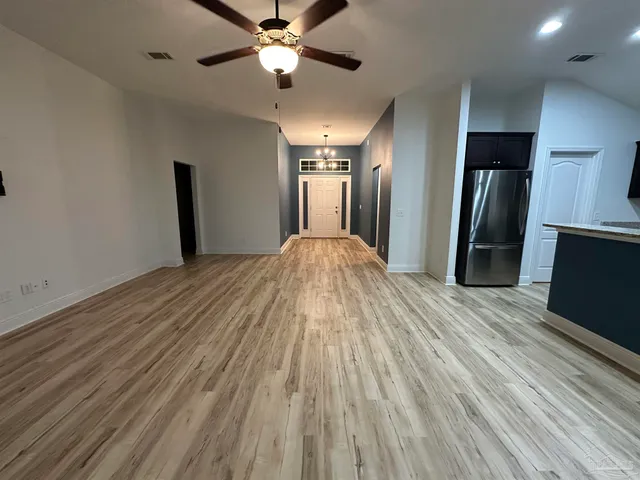 a view of hallway with wooden floor and chandelier