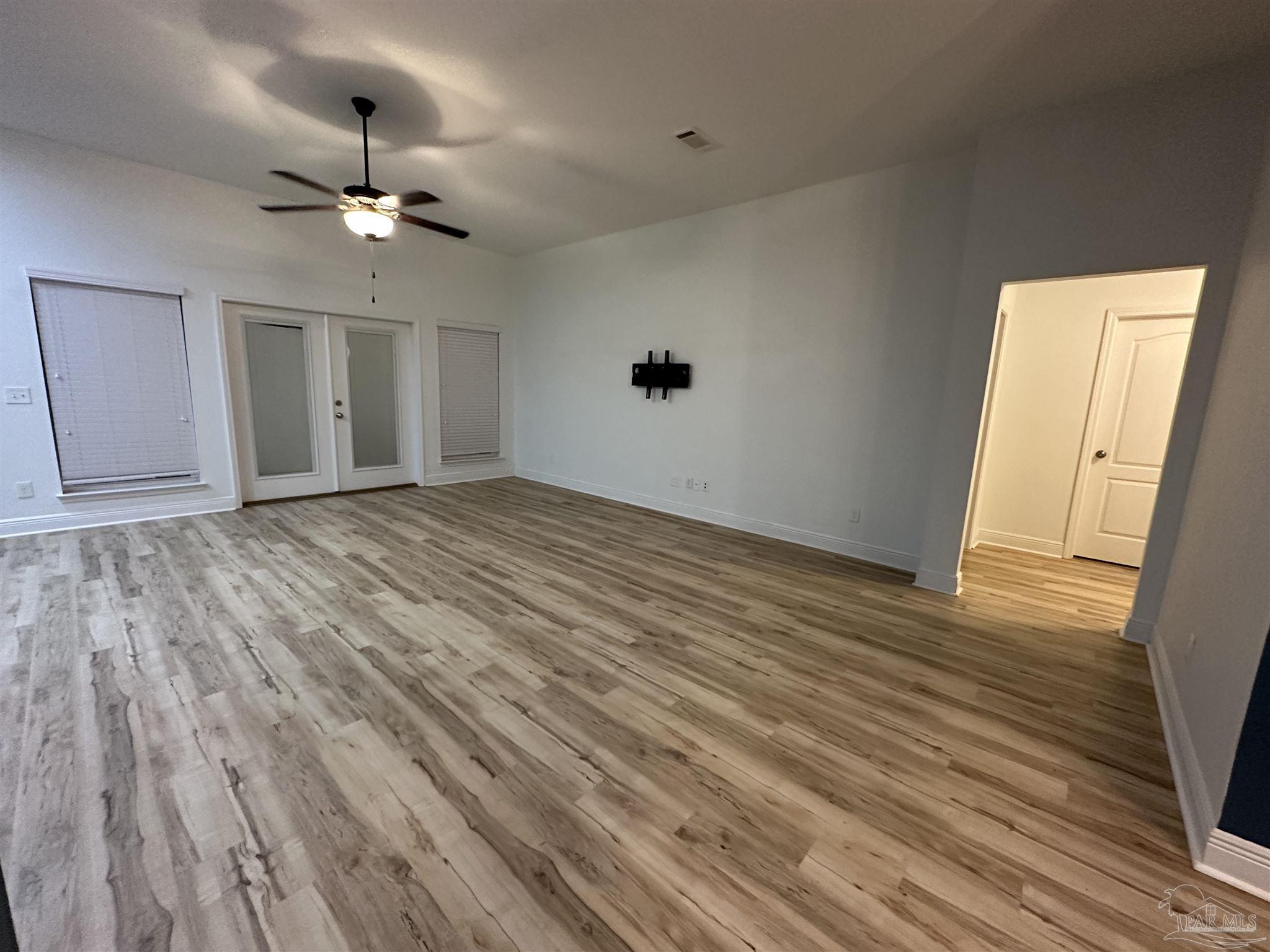 7329 Farmers Road Pensacola, FL 32526 - Photo 7 of 27 a view of an empty room with wooden floor and a ceiling fan