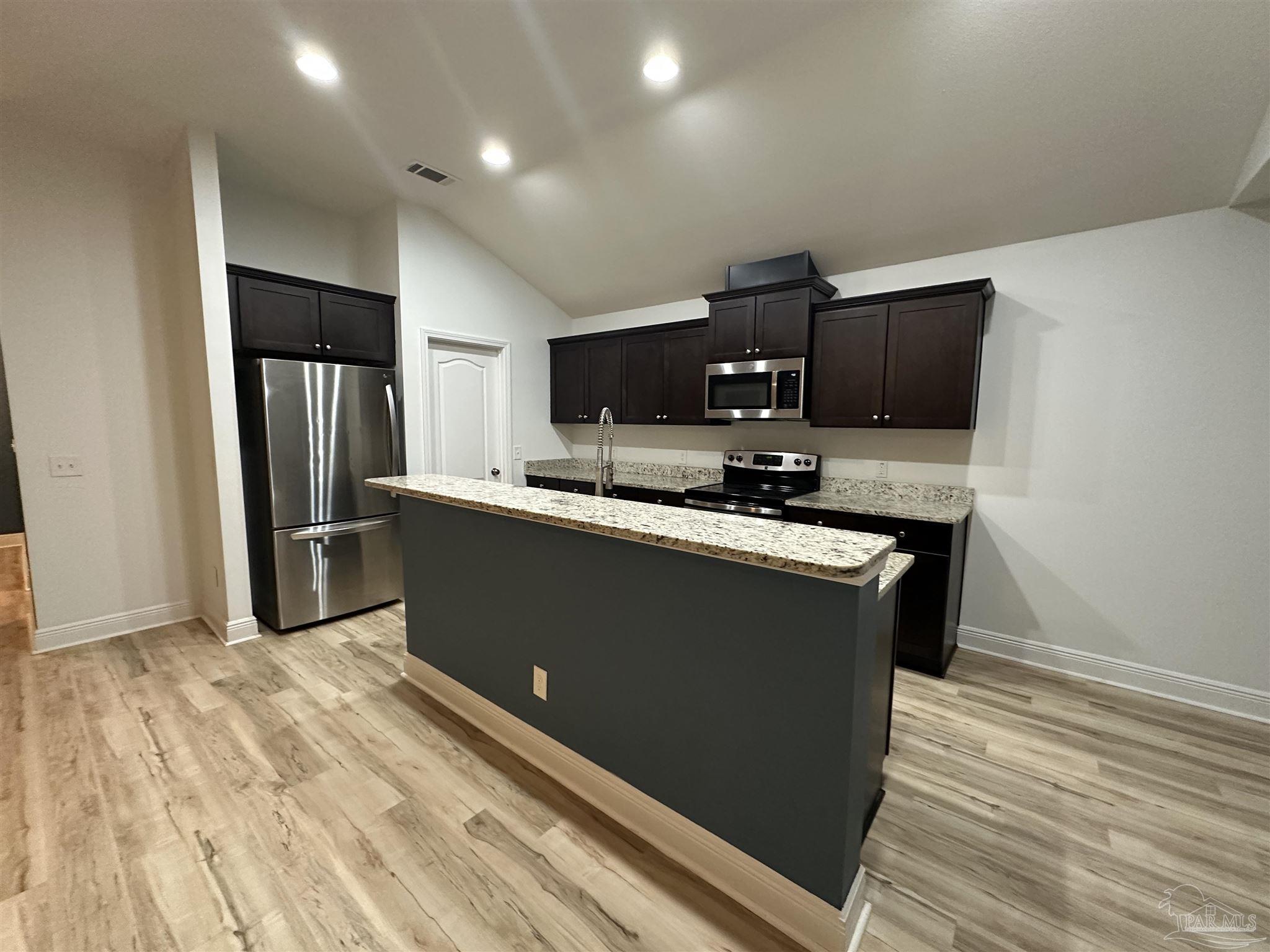 7329 Farmers Road Pensacola, FL 32526 - Photo 10 of 27 a kitchen with stainless steel appliances granite countertop a refrigerator a stove a sink and a microwave