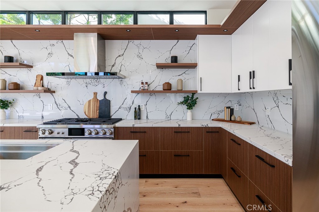 1813 Walnut Avenue Manhattan Beach, CA 90266 - Photo 28 of 73 a kitchen with stainless steel appliances granite countertop a sink and wooden cabinets