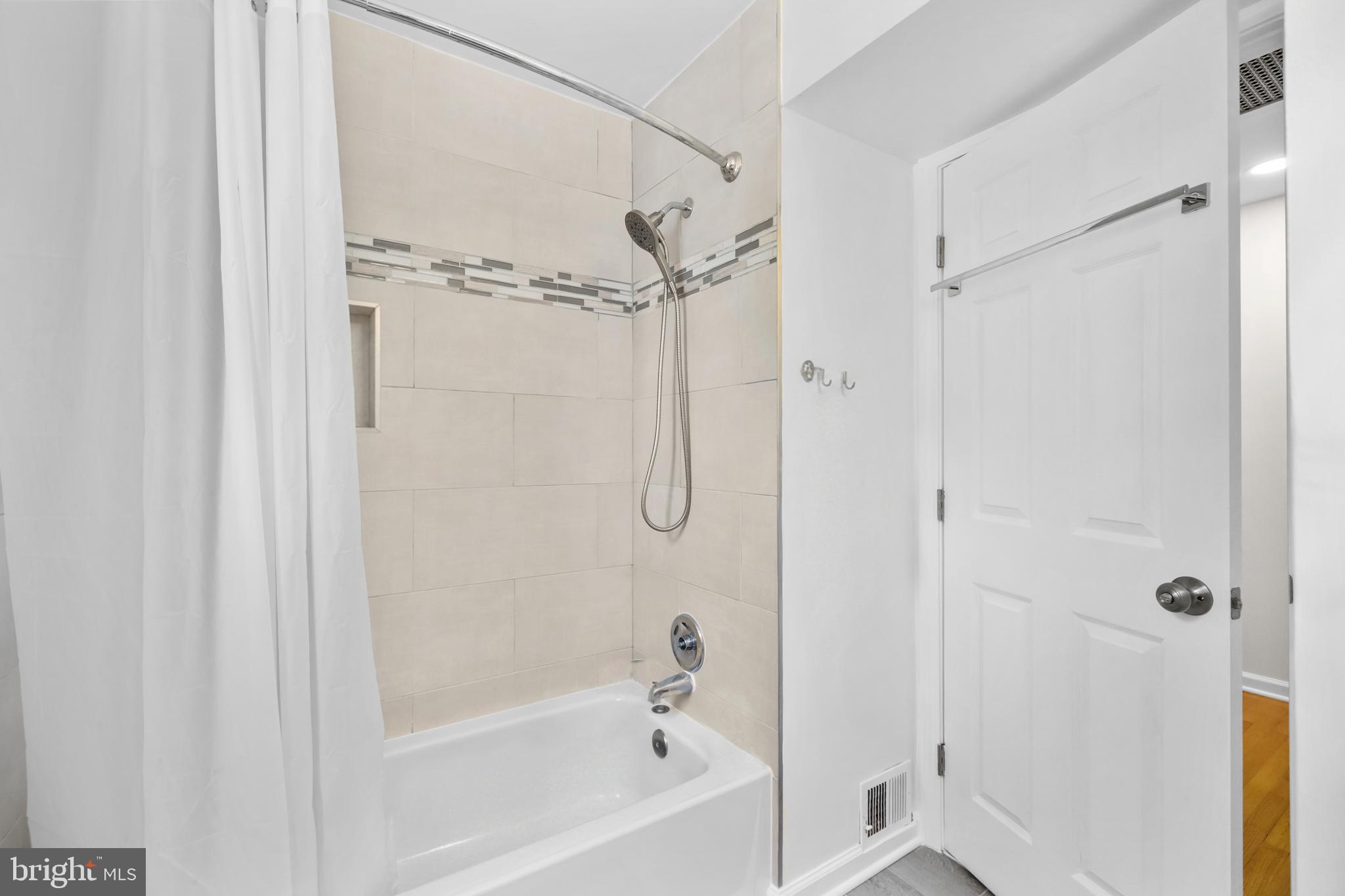 7402 Dunston Street Springfield, VA 22151 - Photo 22 of 37 a bathroom with a glass shower door