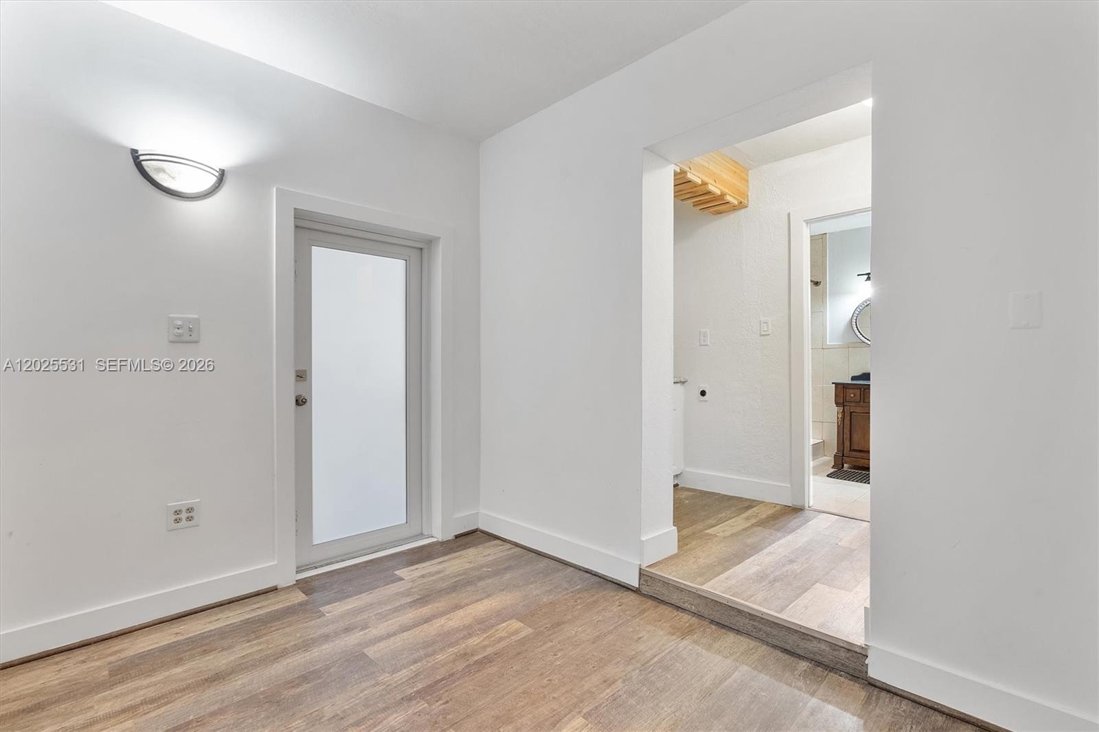 3951 Southwest 2nd Terrace, Unit 3951 Miami, FL 33134 - Photo 14 of 21 an empty room with wooden floor and a mirror