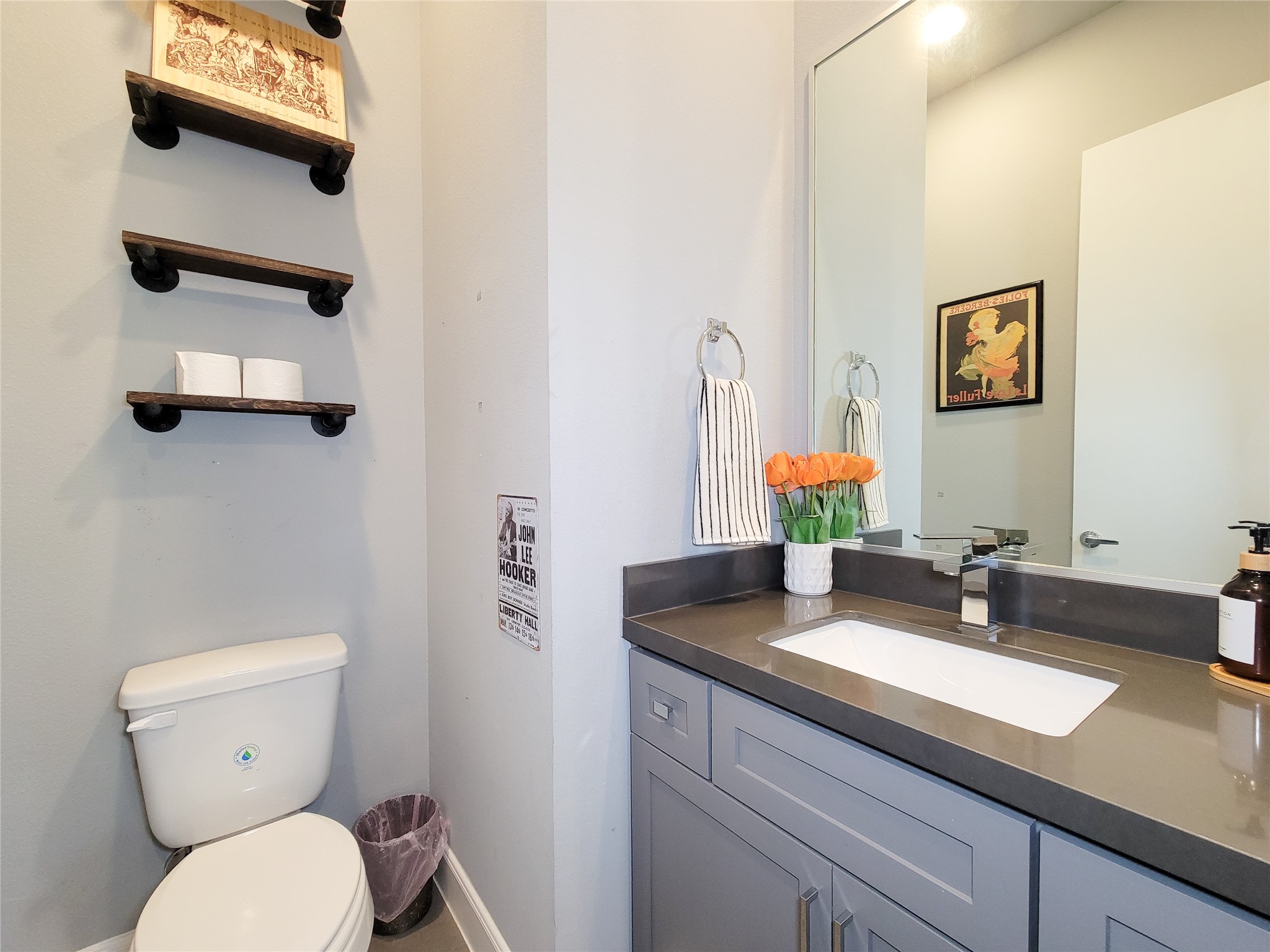 1705 Eado Point Lane Houston, TX 77003 - Photo 33 of 50 The half bathroom features a sleek, dark countertop and a large mirror above a stylish vanity.