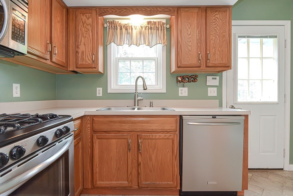 41 Boston Hill Road Fairhaven, MA 02719 - Photo 7 of 32 a kitchen with cabinets appliances a sink and a window