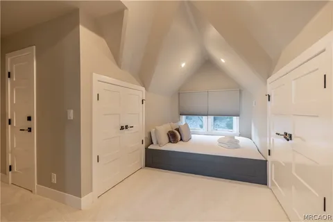 a bedroom with a bed a window and dresser