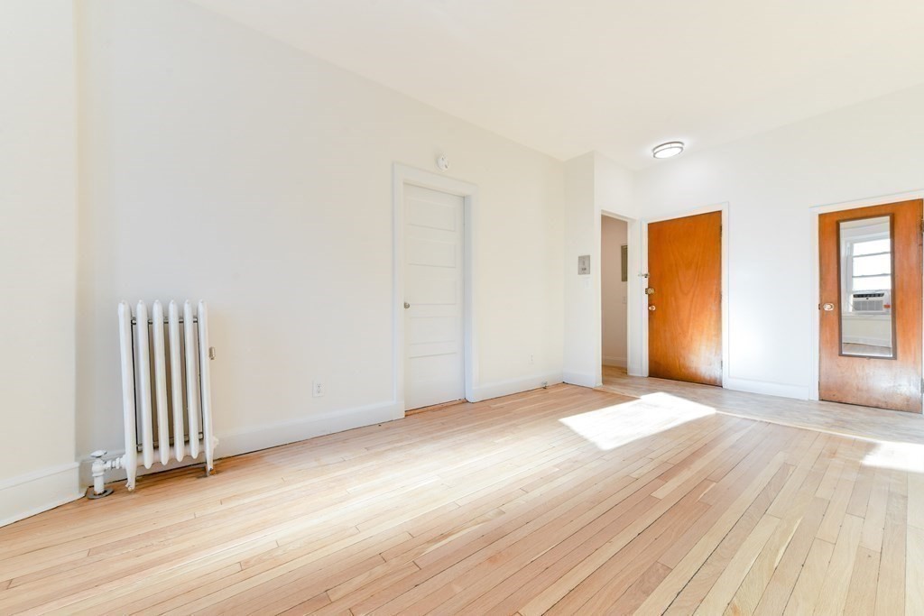 36 Winchester Street, Unit 2 Brookline, MA 02446 - Photo 4 of 14 an empty room with wooden floor and windows