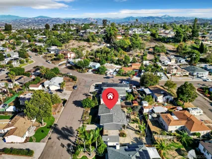 an aerial view of residential houses with outdoor space and parking