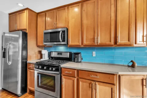 a kitchen with stainless steel appliances granite countertop a stove a microwave and a refrigerator