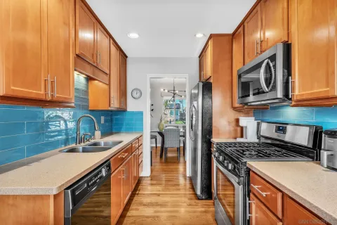 a kitchen with stainless steel appliances granite countertop a stove a sink and a microwave