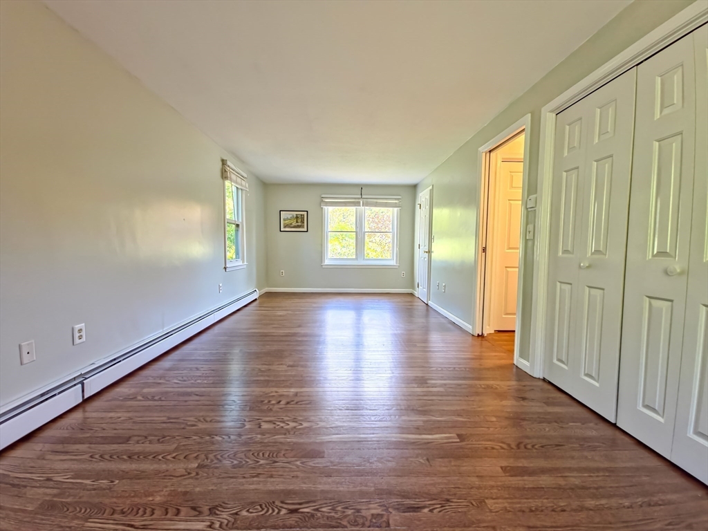 61 Wintergreen Road Mashpee, MA 02649 - Photo 15 of 35 an empty room with wooden floor and windows with curtains