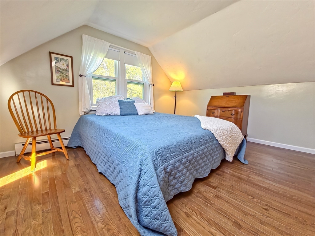 61 Wintergreen Road Mashpee, MA 02649 - Photo 23 of 35 a bedroom with a bed a chair and a large window