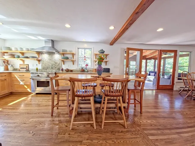 a dining area with stainless steel appliances a dining table chairs and view of living room