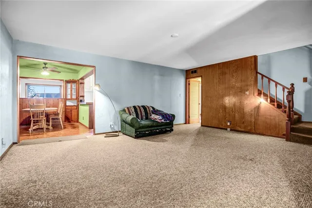 a view of an empty room with window and stairs