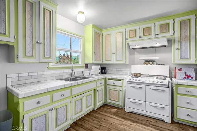 a kitchen with a sink cabinets and wooden floor