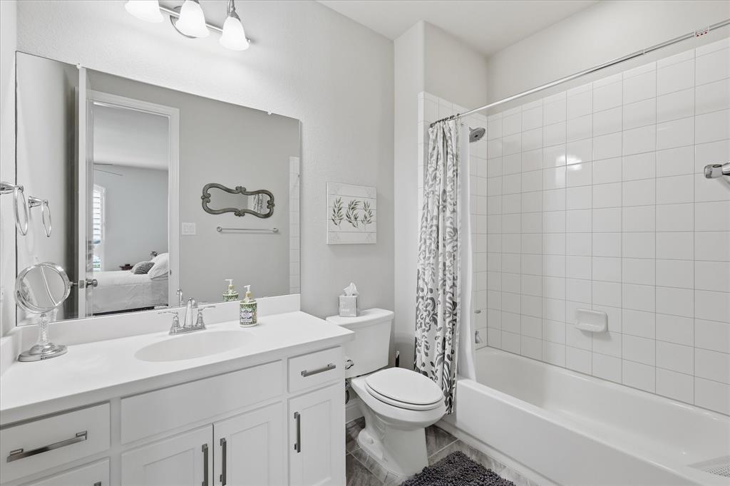 9708 Surveyor Road Oak Point, TX 75068 - Photo 27 of 34 Bathroom featuring a white vanity with integrated sink, chrome faucet, and cabinet storage