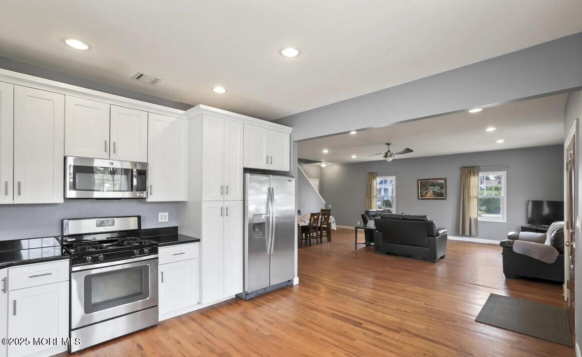 2207 Main Street Lake Como, NJ 07719 - Photo 4 of 22 a kitchen with stainless steel appliances a refrigerator a stove top oven a sink cabinets and living room view