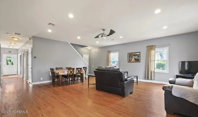 a living room with furniture and a wooden floor