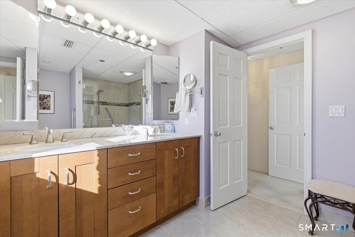 707 East Mix Avenue, Unit 38 Hamden, CT 06514 - Photo 16 of 26 a bathroom with a granite countertop sink a mirror and a shower