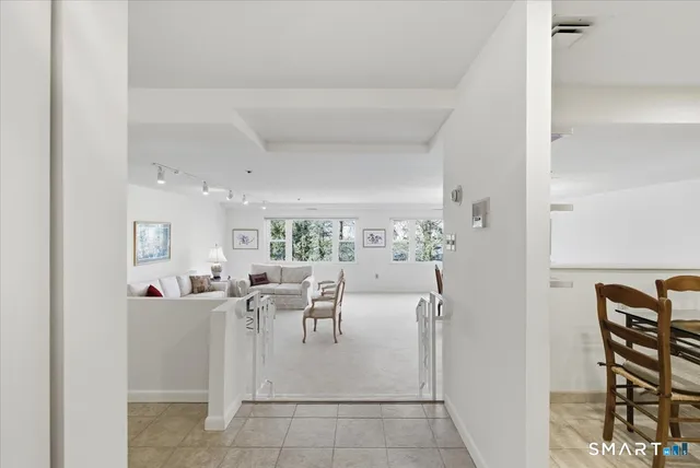 a living room with furniture a rug and white walls