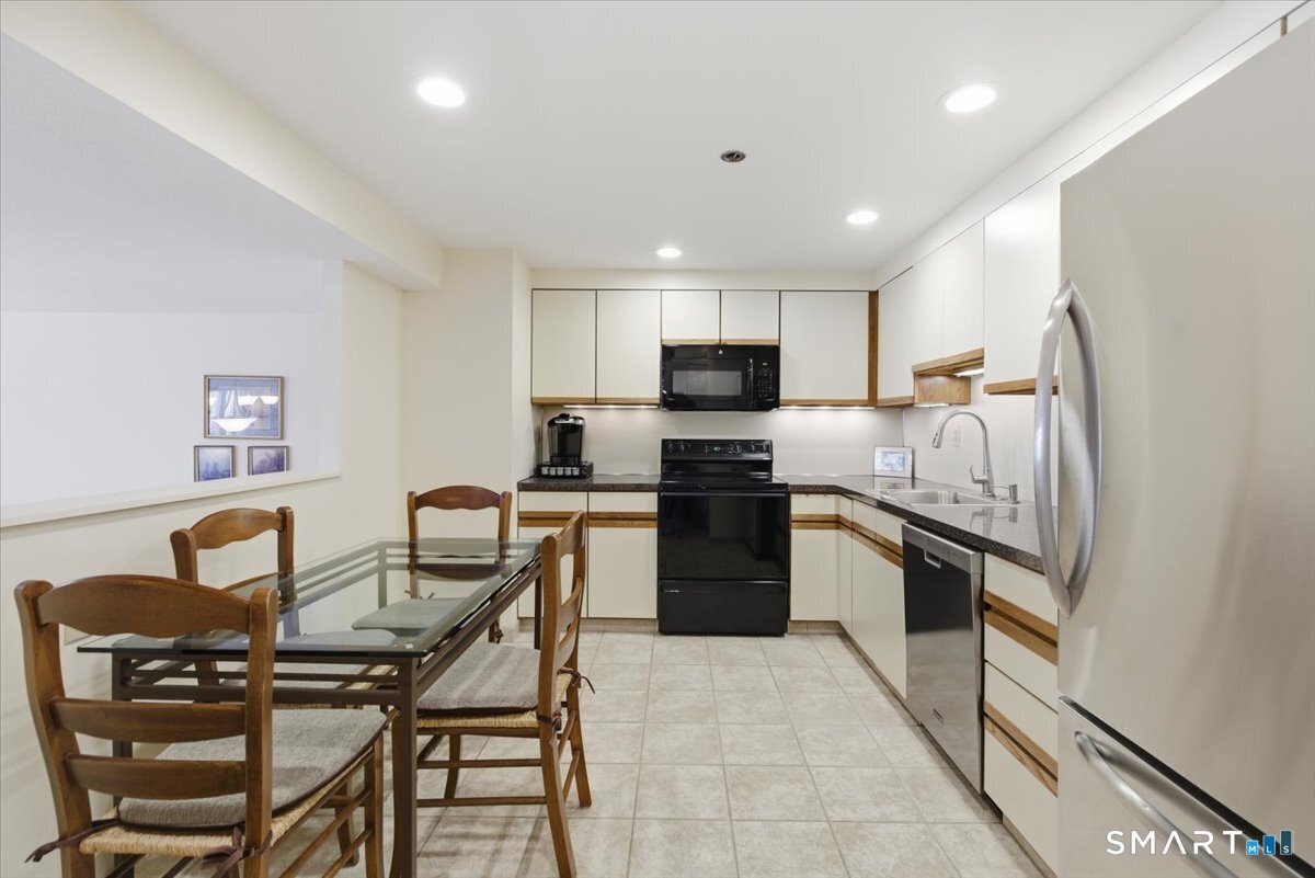 707 East Mix Avenue, Unit 38 Hamden, CT 06514 - Photo 10 of 26 a kitchen with a refrigerator and a stove top oven