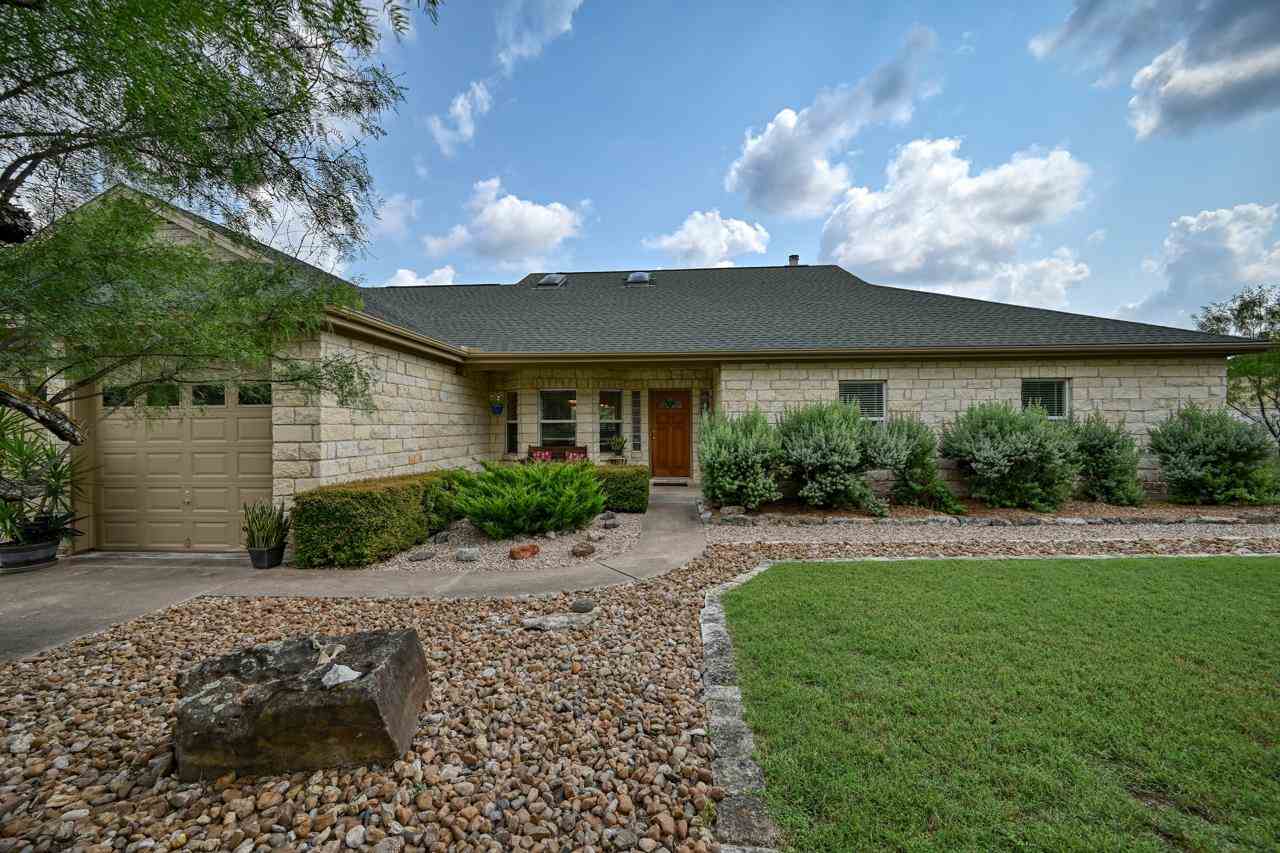 945 Wesley Ridge Drive Spicewood, TX 78669 - Photo 1 of 1 a front view of a house with garden