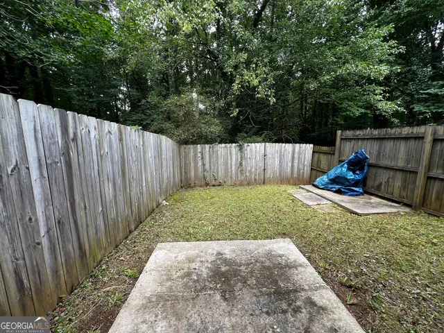 a view of backyard with wooden fence