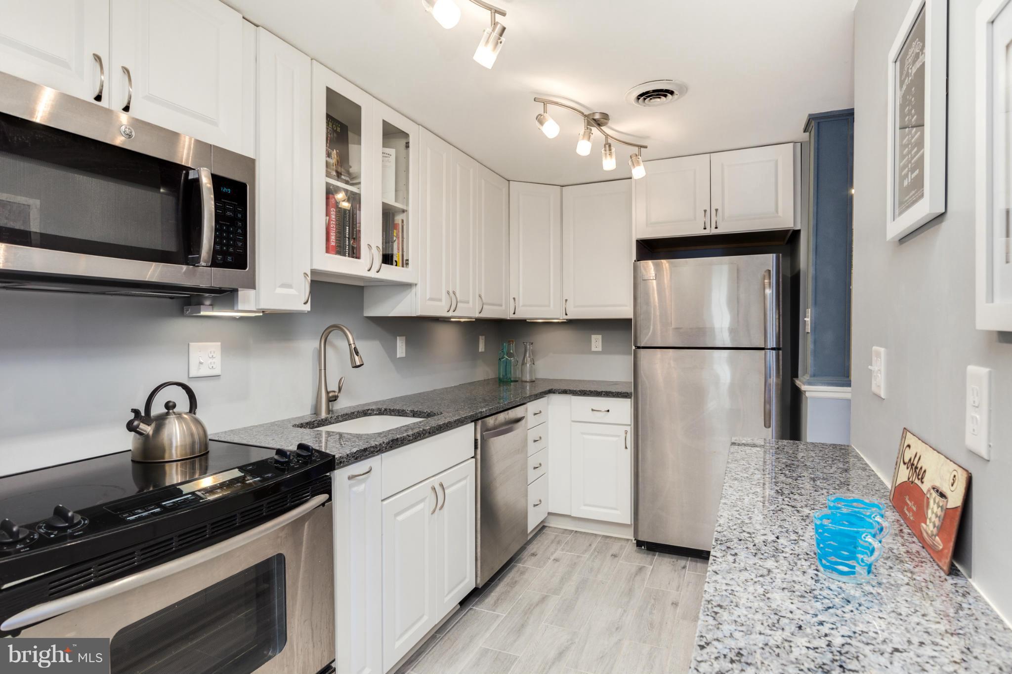 3035 Q Street Northwest, Unit 1 Washington, DC 20007 - Photo 7 of 19 a kitchen with stainless steel appliances a stove microwave sink and refrigerator