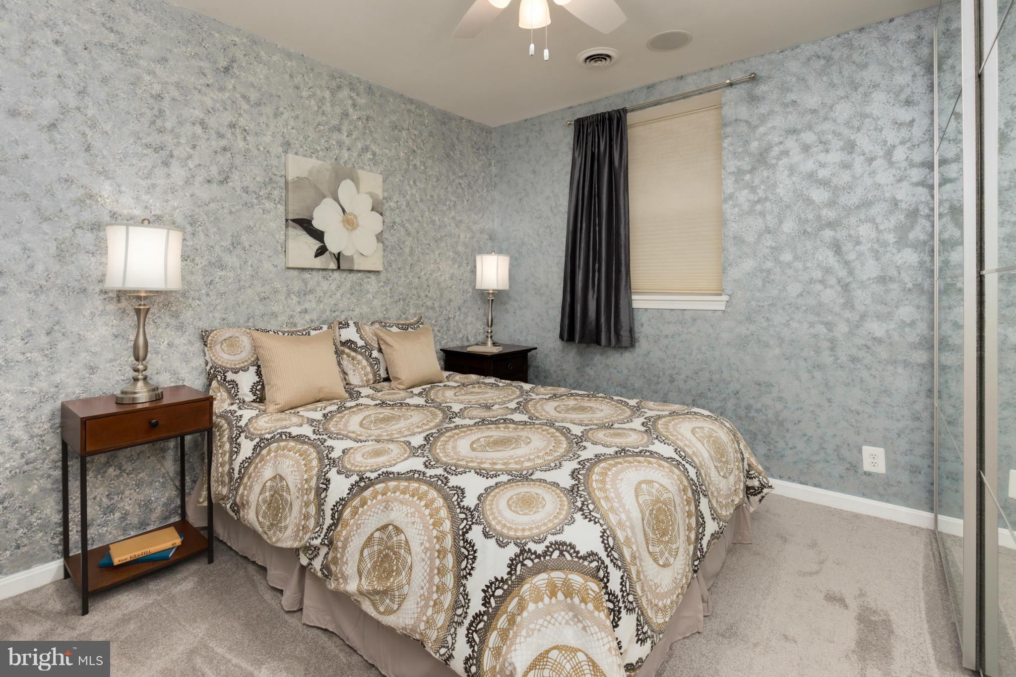 3035 Q Street Northwest, Unit 1 Washington, DC 20007 - Photo 10 of 19 a bedroom with a bed and a lamp on dresser