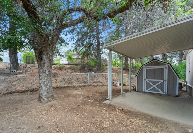 2875 North 400 West, Unit 7 Layton, UT 84041 - Photo 3 of 29 Covered carport with concrete pad, featuring a detached storage shed