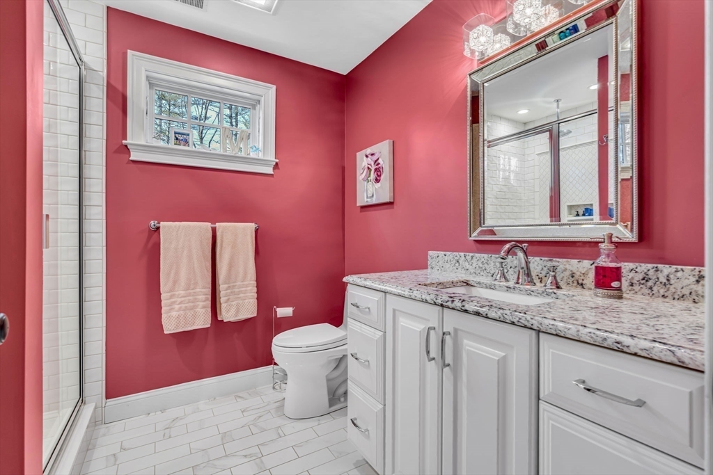 134 Pope Road Acton, MA 01720 - Photo 31 of 39 a bathroom with a granite countertop toilet a sink a mirror and a window