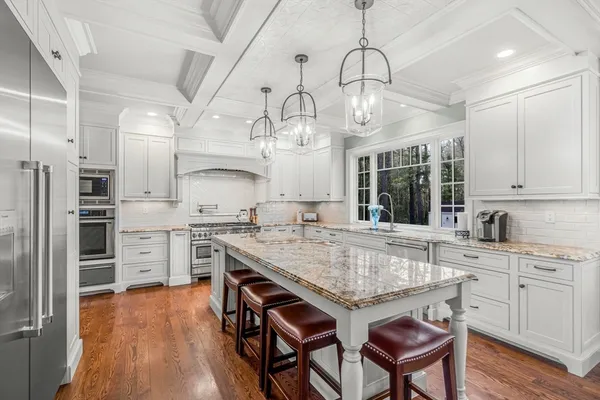 a kitchen with granite countertop a stove and a white cabinets