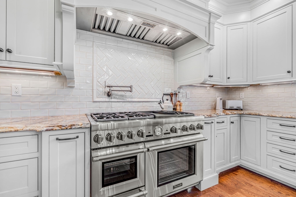 134 Pope Road Acton, MA 01720 - Photo 10 of 39 a kitchen with granite countertop a stove and a white cabinets