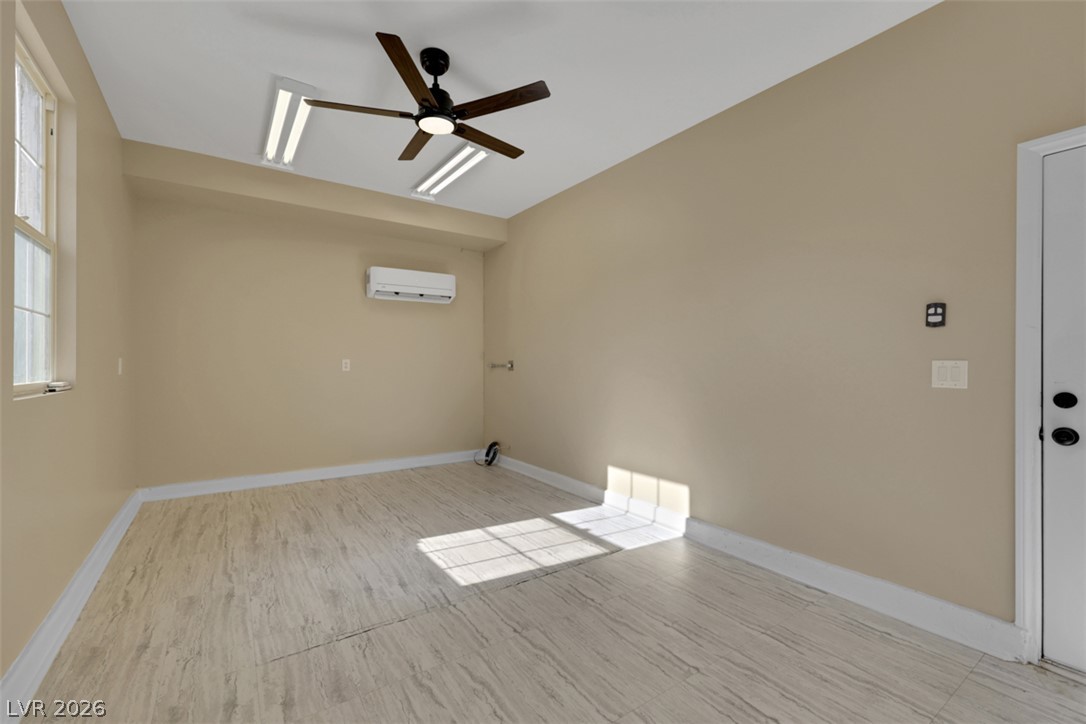 10328 Hawk Ravine Street Las Vegas, NV 89178 - Photo 53 of 55 An airy space with a window, modern ceiling fan, and sleek flooring.
