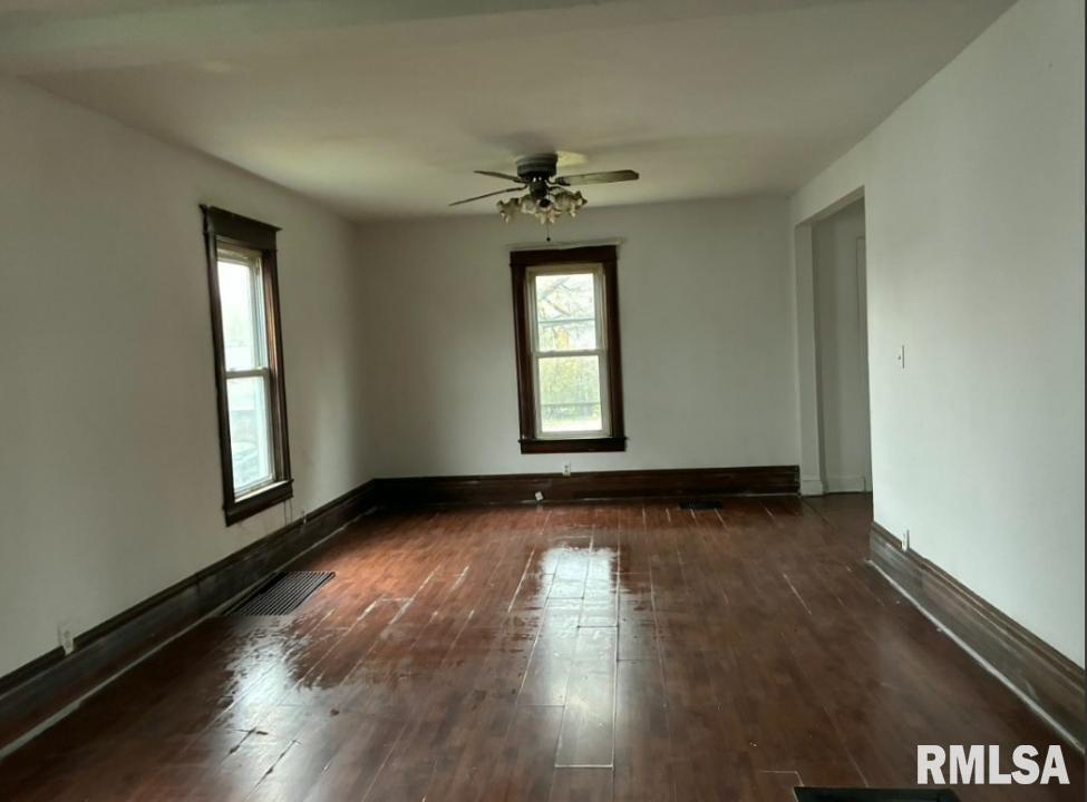 732 South Main Street Kewanee, IL 61443 - Photo 4 of 13 an empty room with wooden floor and windows
