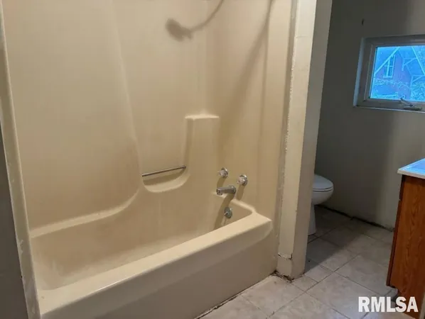 a white bath tub sitting next to a toilet