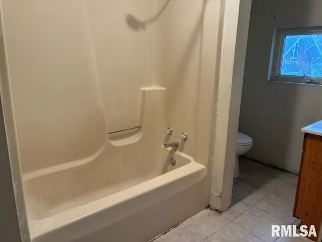 a white bath tub sitting next to a toilet