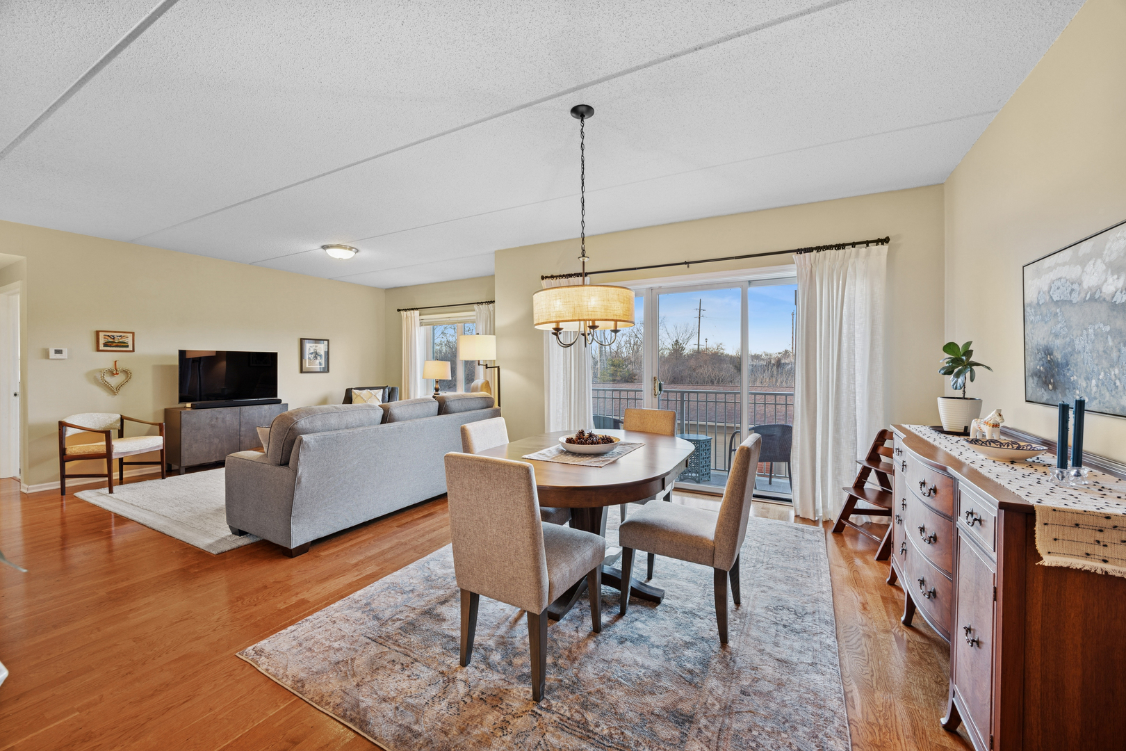 500 East St Charles Road, Unit 209 Lombard, IL 60148 - Photo 6 of 21 a living room with furniture a flat screen tv and a large window