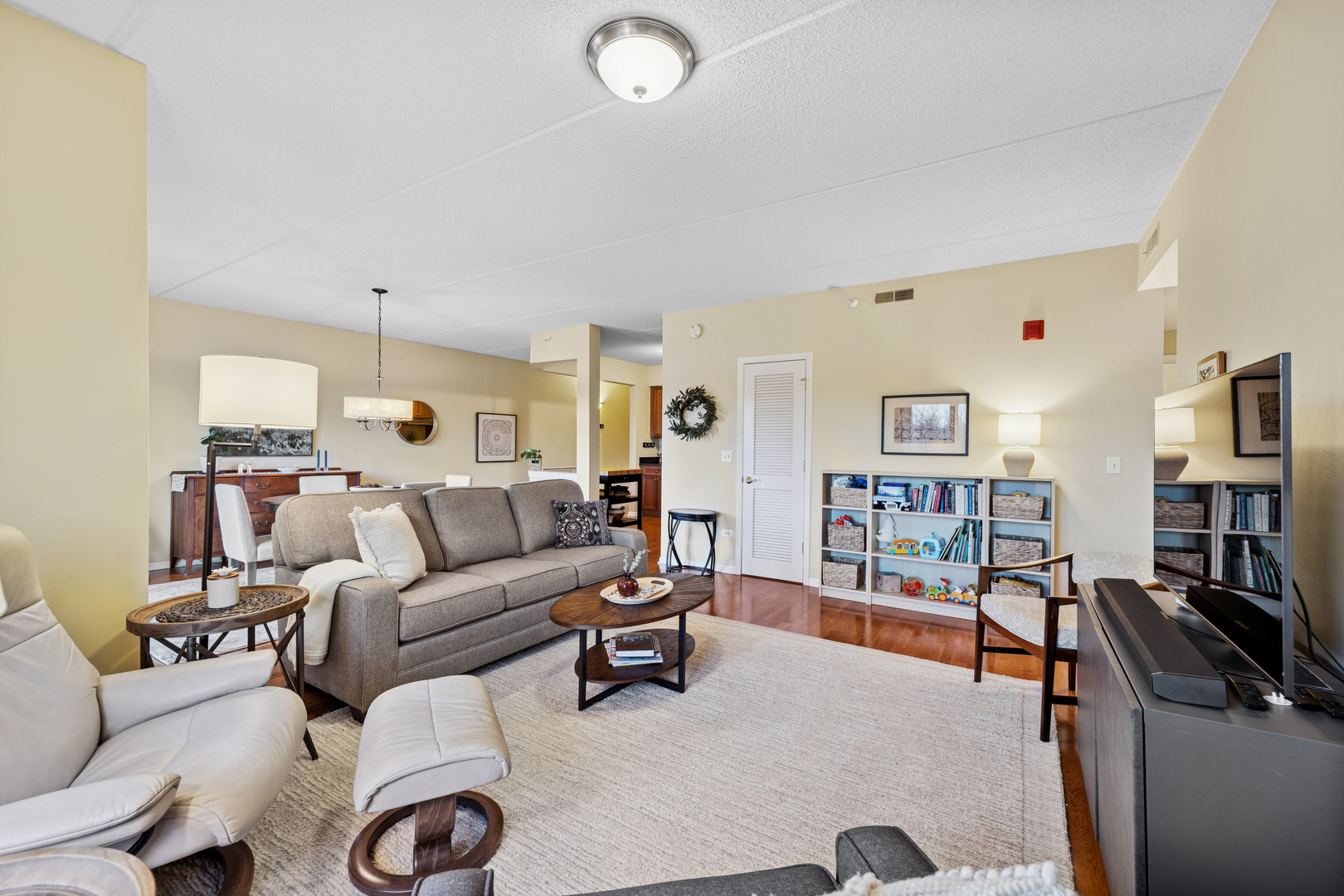 500 East St Charles Road, Unit 209 Lombard, IL 60148 - Photo 9 of 21 a living room with furniture a bookshelf and a flat screen tv