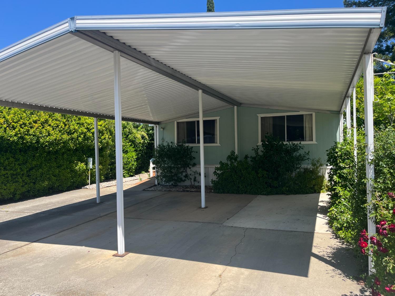 a patio with table and chairs and potted plants
